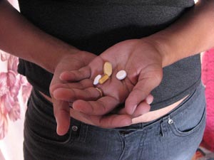 An HIV positive South African woman holding her antiretroviral drugs