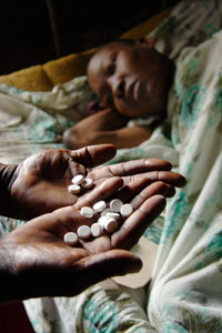 A community health worker gives an HIV positive patient antiretroviral drugs, Kenya